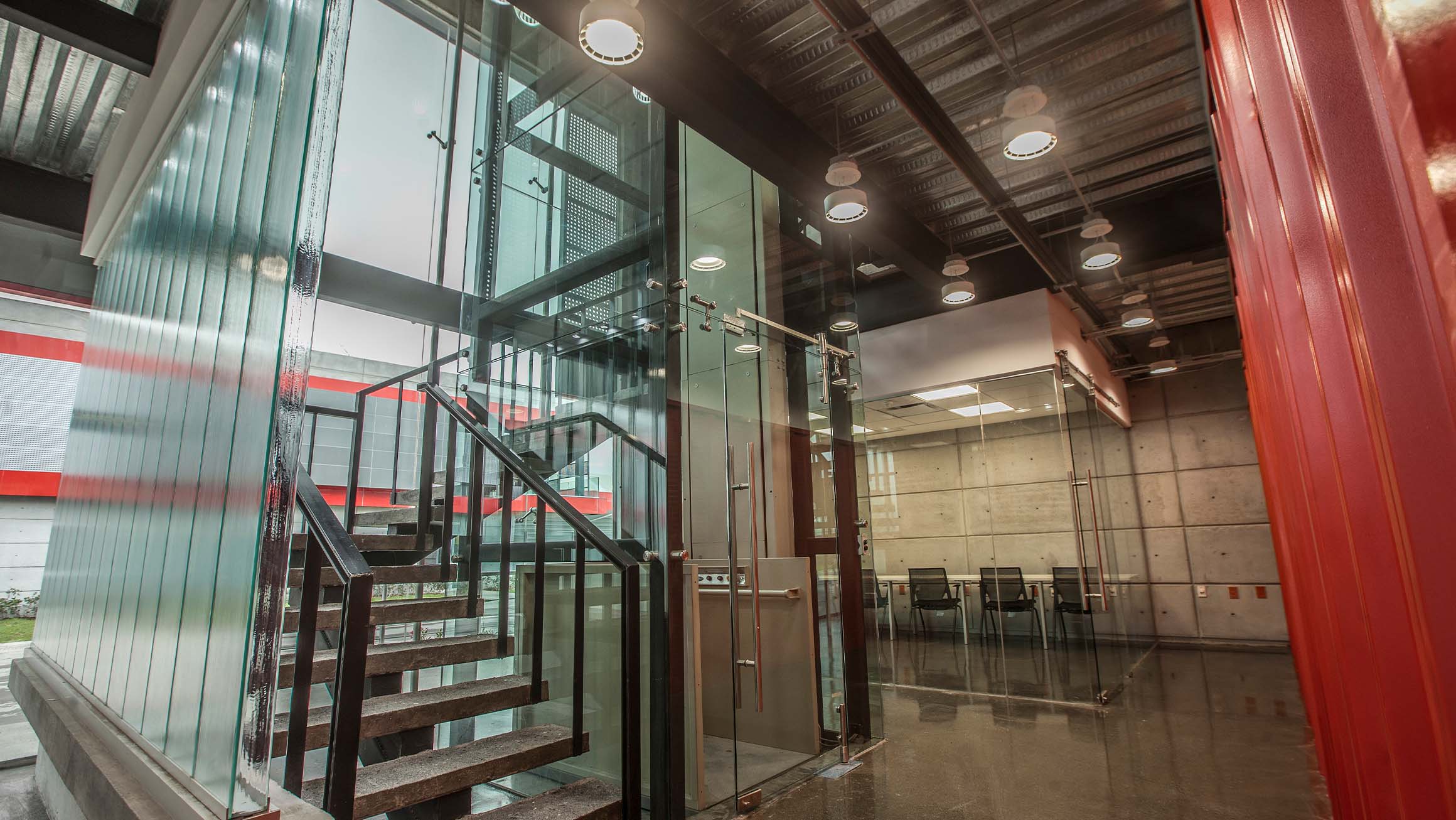 Interior photograph of a custom made office buiding with glass walls, showing stairs and en elevator