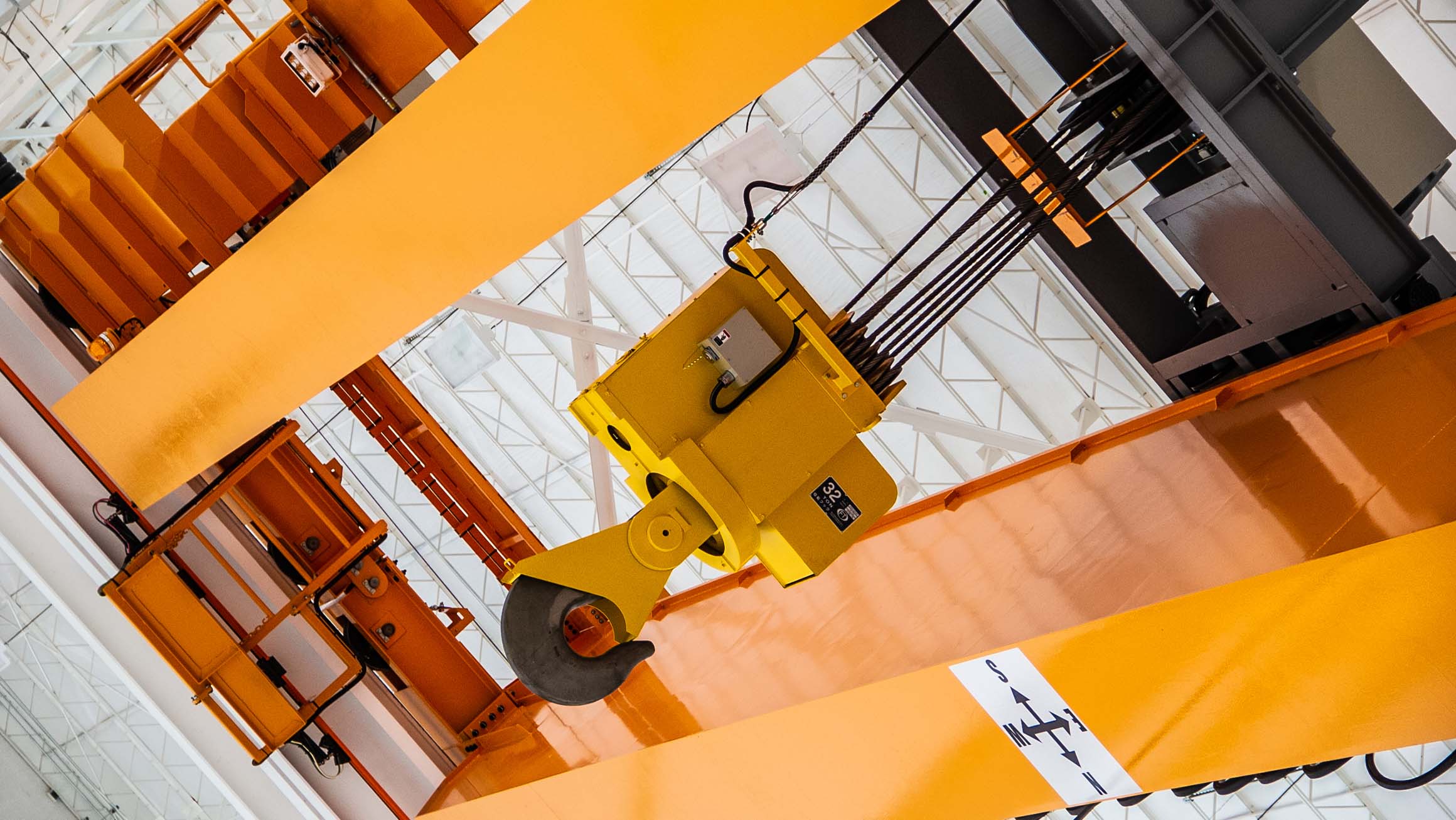 Photograph of a yellow overhead industrial crane located inside an industrial park building for DAVISA