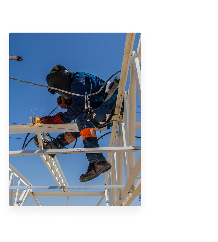 Construction worker soldering a metal structure in an industrial park construction site